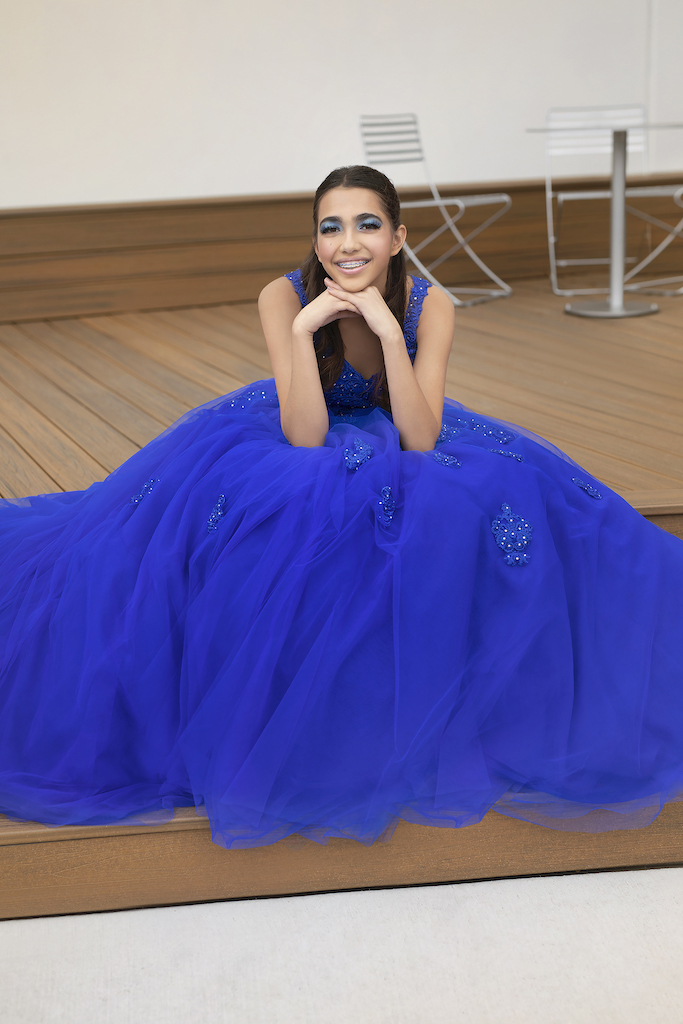 cô gái tuổi teen ngồi trong chiếc váy quinceañera màu xanh coban