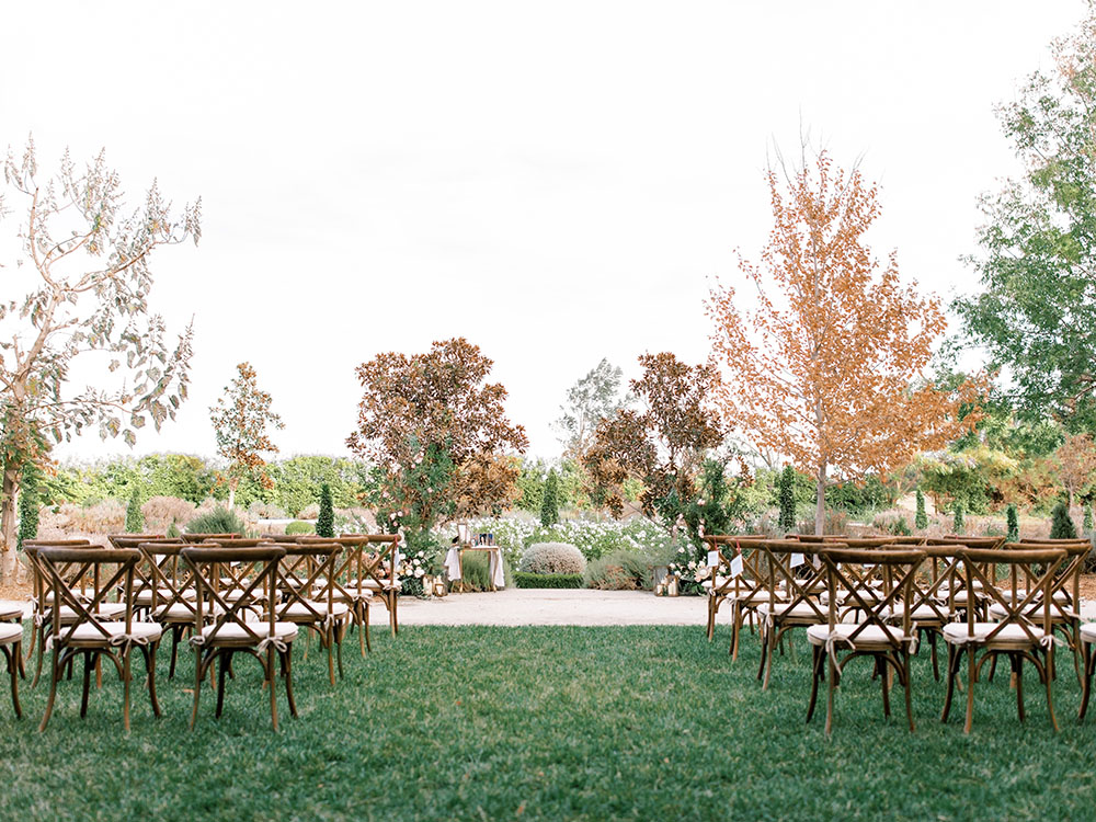 Địa điểm tổ chức đám cưới ở Bắc California Park Winters với một khu vườn trũng sâu và những chiếc ghế dựa lưng bằng gỗ