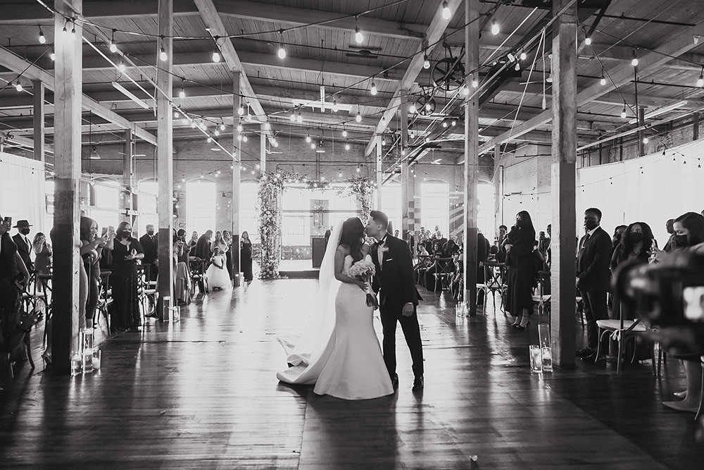 cô dâu và chú rể hôn nhau trong giờ giải lao tại địa điểm tổ chức đám cưới của một xưởng nghệ thuật
